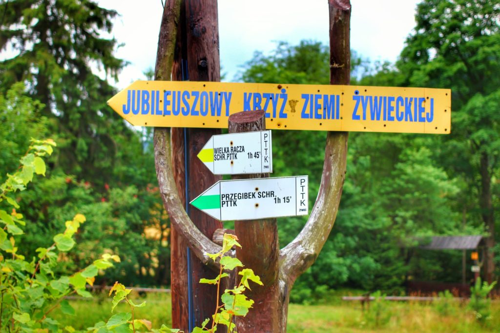 Drogowskaz opisujący szlak zielony na Przegibek, żółty na Wielką Raczę, żółta strzałka na Jubileuszowy Krzyż Ziemi Żywieckiej