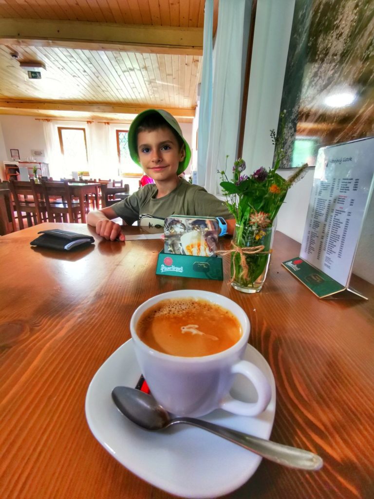 Bufet Rohacki – Taliakowa Chata - uśmiechnięte dziecko siedzące przy stoliku, filiżanka z kawą