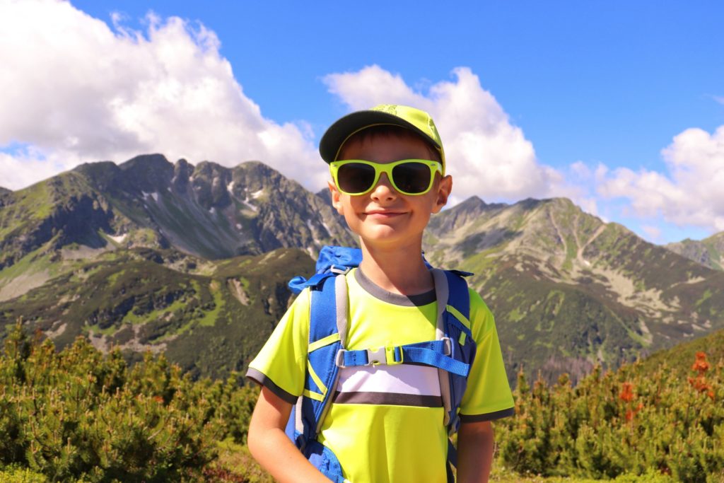 Szczęśliwe dziecko w drodze na Wołowiec pozujące na tle Tatr w miejscu Zabratowa Przełęcz