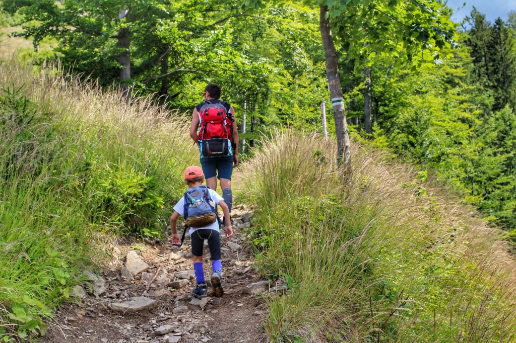 Turysta z dzieckiem na askiej ścieżce leśnejna szlaku zielonym prowadzącym do schroniska Przegibek