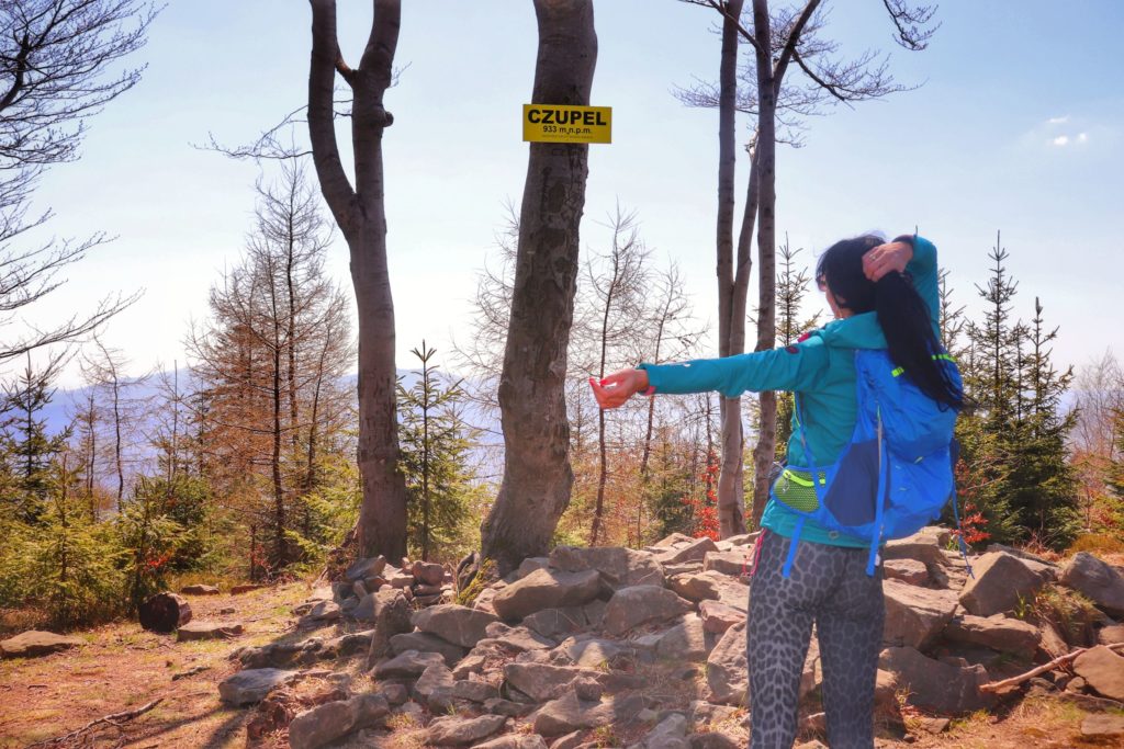Turystka na szczycie Czupel, stojąca tyłem, kamienie, drzewa