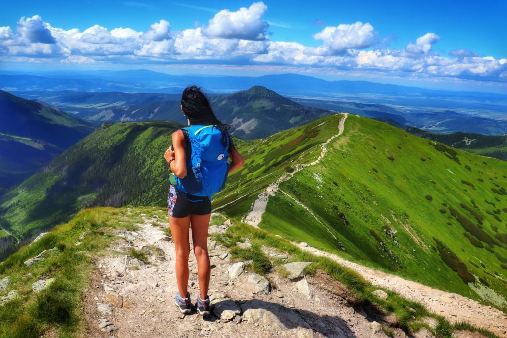 Turystka patrząca w stronę szczytu Rakoń, tatrzański szlak na Wołowiec, piękny, letni dzień