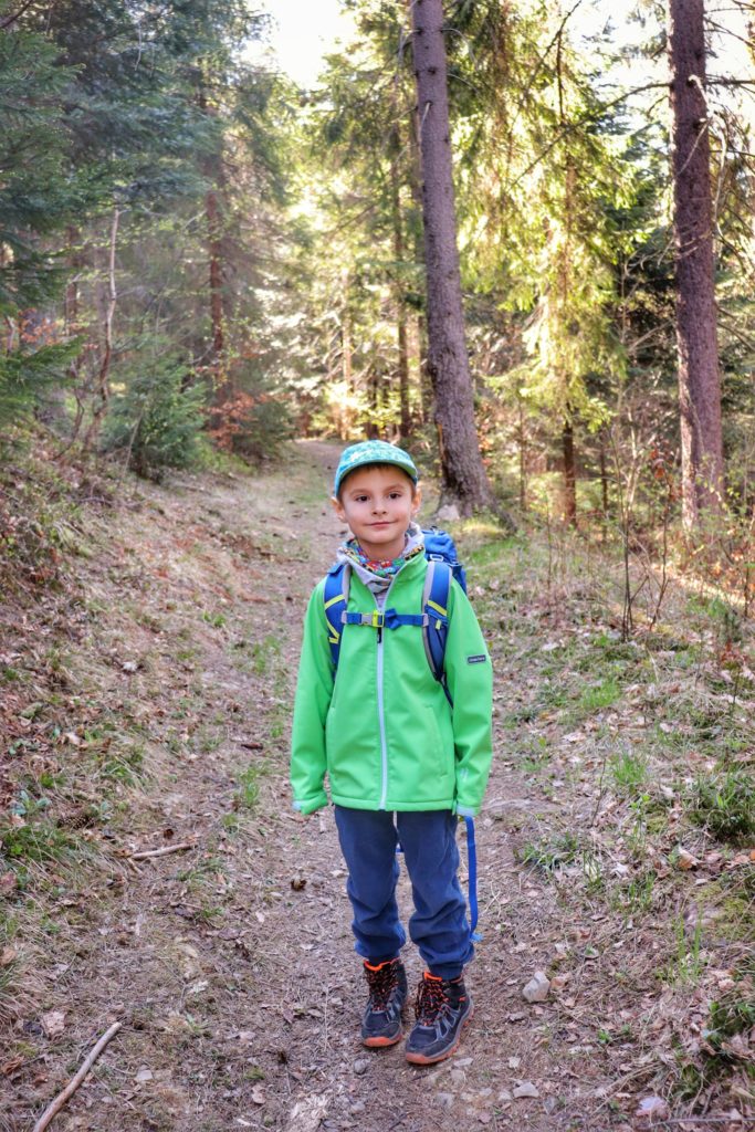 Zadowolone dziecko, leśna ścieżka, słoneczny dzień