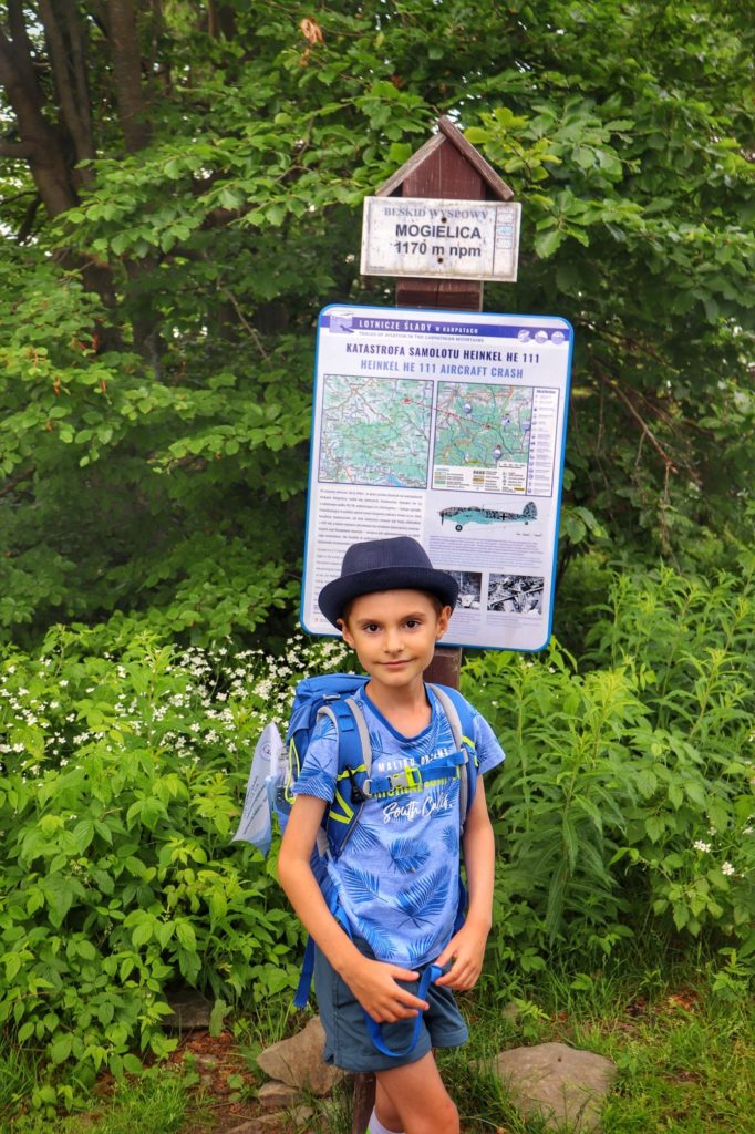 Dziecko stojące przy tablicy opisującej katastrofę lotniczą na szczycie Mogielica'