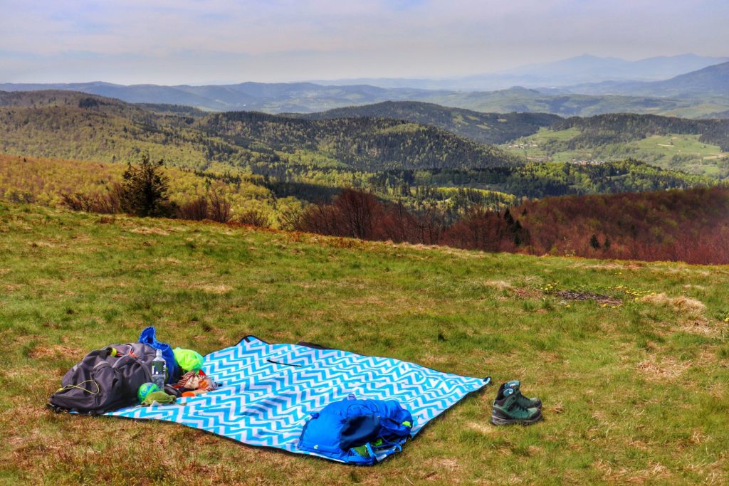 Polana Wyśnikówka,na której jest rozłożony koc piknikowy, w oddali piękny krajobraz górski