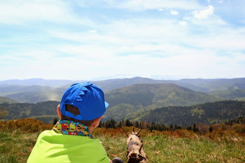 Polana Stumorgowa, dziecko podziwiające widoki górskie, wtym wynurzające się w oddali Tatry, ciepłe majowe popołudnie