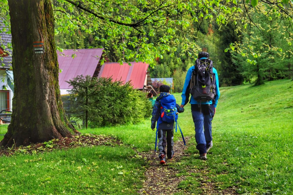Słowianka z dzieckiem, turysta idący z chłopcem czarnym szlakiem, polna ścieżka, maj