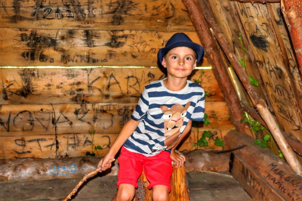 Uśmiechnięte dziecko w drewnianym szałasie na Polanie Janoszkowej