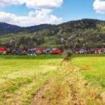 Widok na Wieś Koszarawa z żółtego szlaku na Jałowiec,polna ścieżka, kwitnące drzewa