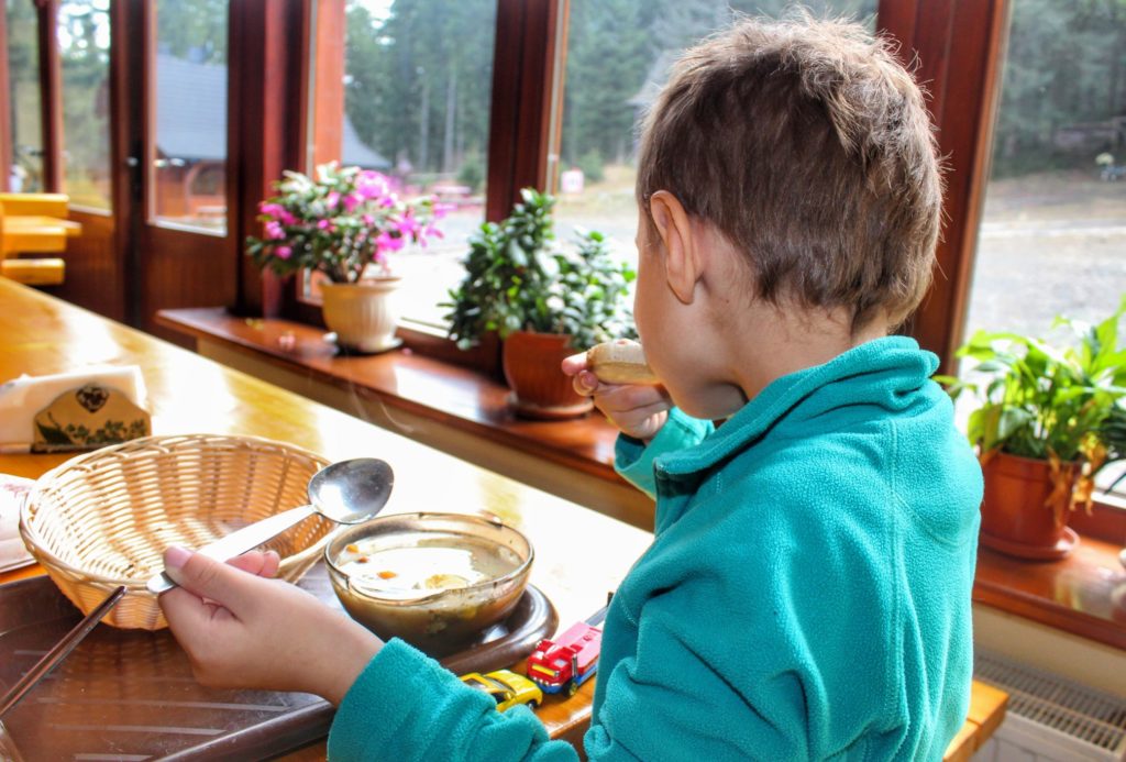 Dziecko jedzące zupę - żurek z chlebem w schronisku Markowe Szczawiny