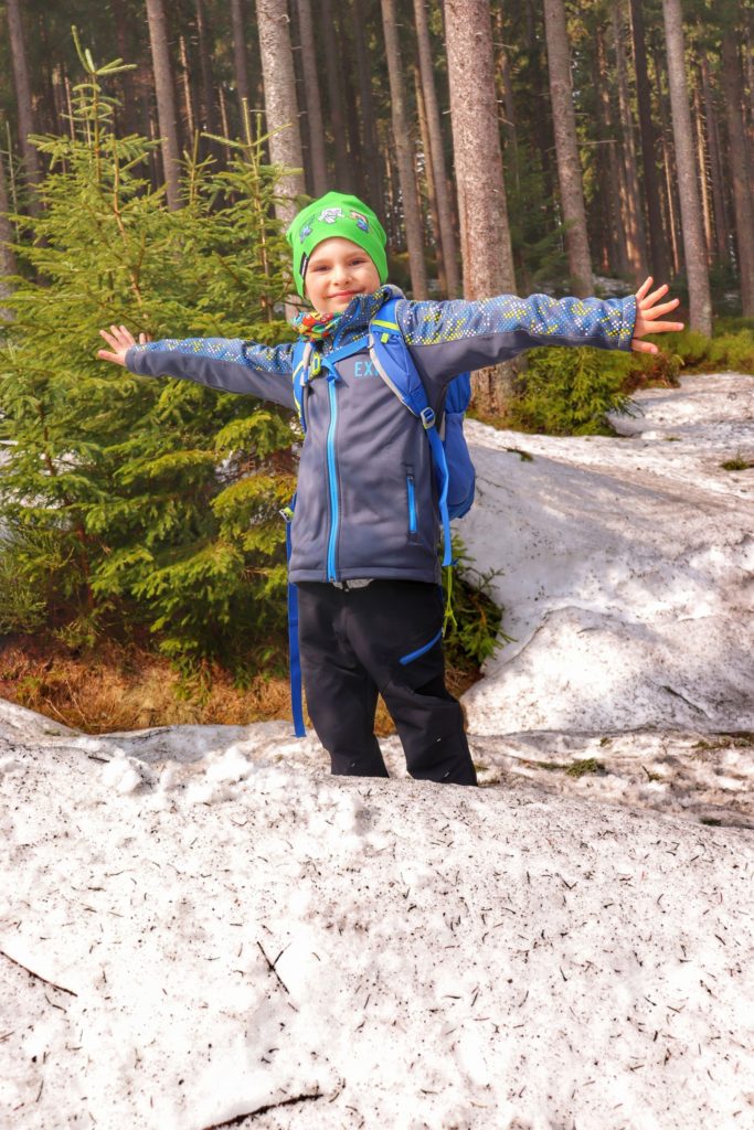 Szczęśliwe dziecko z rozłożonymi rękami w lesie w drodze na Halę Cudzichową, śnieg
