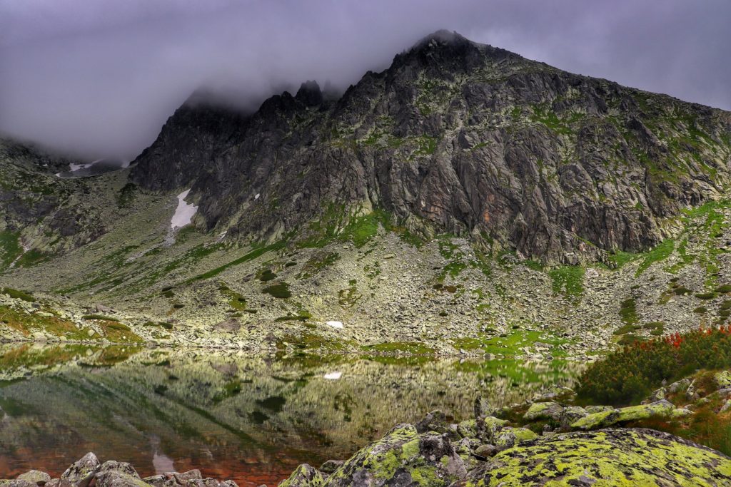 Tatry Wysokie, widok rozciągający się z brzegu Batyżowieckiego Stawu, chmury nad tatrzańskimi szczytami