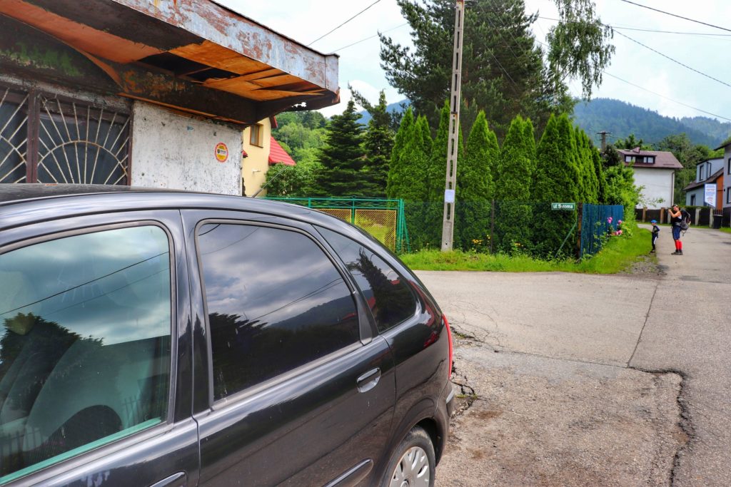 Ulica Spacerowa - skrzyżowani z ulicą Stromą w Lipniku, czarny szlak na Hrobaczą Łąkę, samochód zaparkowany obok nieczynnego sklepu spożywczego, asfaltowa droga