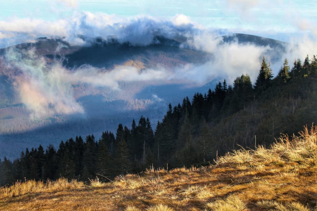 Widok rozciągający się z Przełęczy Brona, październikowe przedpołudnie, krajobraz górski wyłaniający się zza chmur