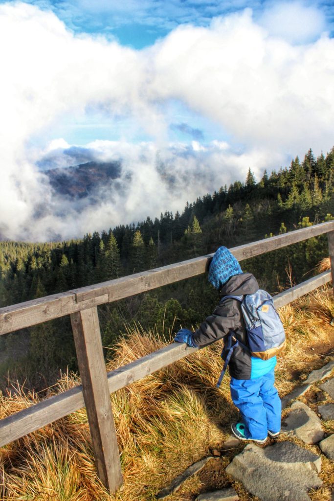 Dziecko na tarasie widokowym mieszczącym się na Przełęczy Brona, zimny, październikowy poranek, chmury