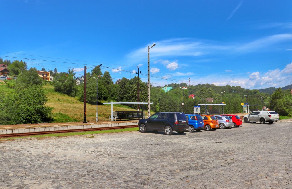 Parking samochodowy znajdujący się przy stacji kolejowej Rytro, piękny, letni dzień