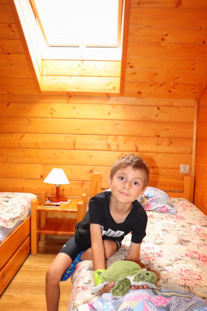 Pokój na poddaszu w schronisku Cyrla, dziecko siedzące na łóżku