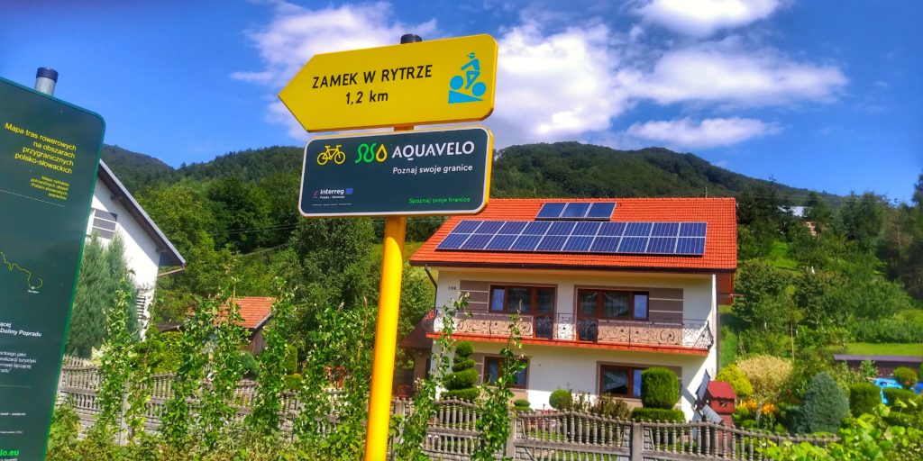 Ulica Sucha Struga, Rytro, żółta tabliczka z napisem Zamek w Rytrze 1,2 kilometra, w tle dom