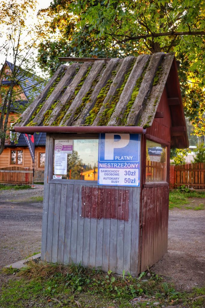 Drewniana budka, parking Dolina Kościeliska, niebieska tabliczka z cennikiem