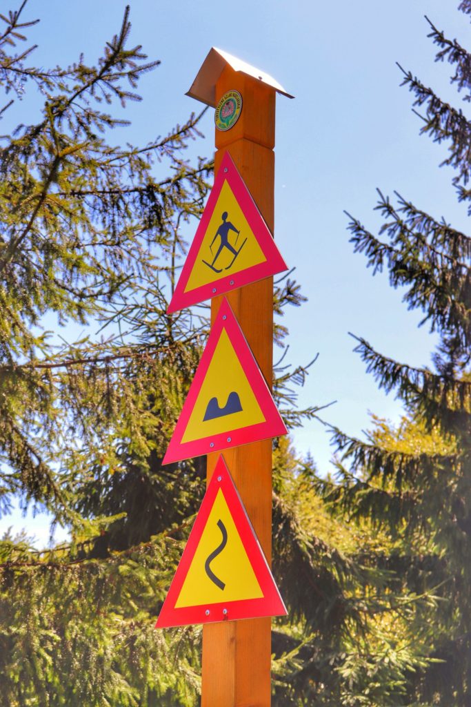 Drewniany słup z oznaczeniami dla narciarzy na Hali Pisanej