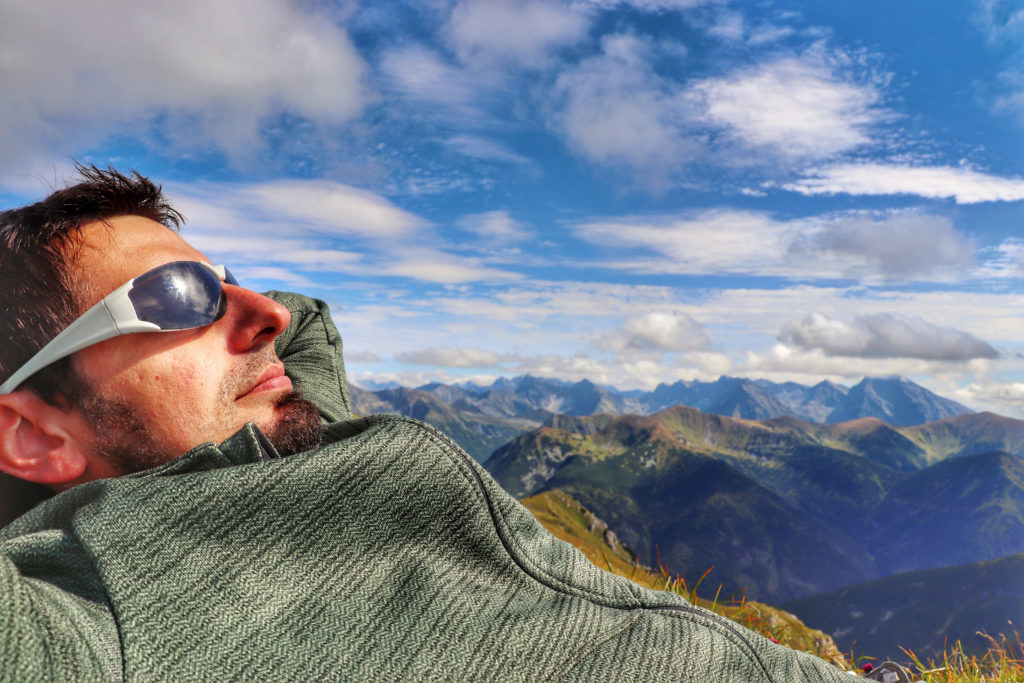 Turysta odpoczywający na szczycie dwutysięcznika - Ciemniak, w tle tatrzańskie szczyty