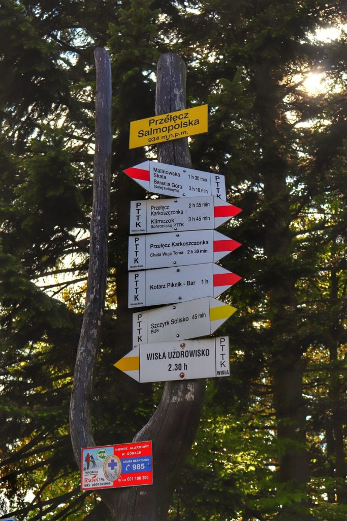 Żółta tabliczka oznaczająca Przełęcz Salmopolską 934 m n.p.m. w Szczyrku, opis przebiegających tu szlaków