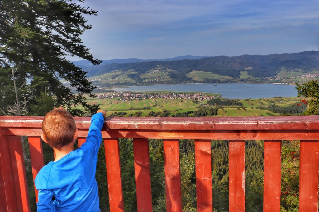 Dziecko podziwiające widoki z drewnianej wieży widokowej na szczycie Żar, Pieniny Spsikie na Jezioro Czorsztyńskie, Gorce