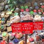 OGRÓD Z KAMIENIAMI na szczycie Klimczok w Beskidzie Śląskim, czerwone tabliczki z napisami - Campo Carlo Magno 1681 M Dolomity, Monte Di San Petru 1400 M Corse, Passo Cingue Croci 2016 M Dolomity