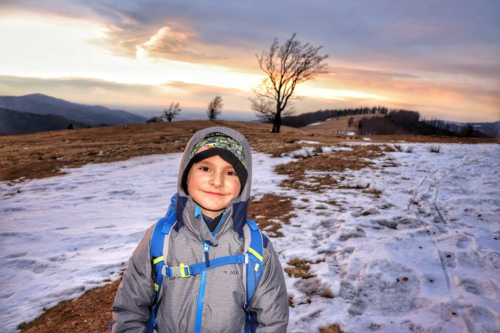 Szczęśliwe dziecko na Hali Jaworowej - zima, kolorowe niebo o zachodzie słońca