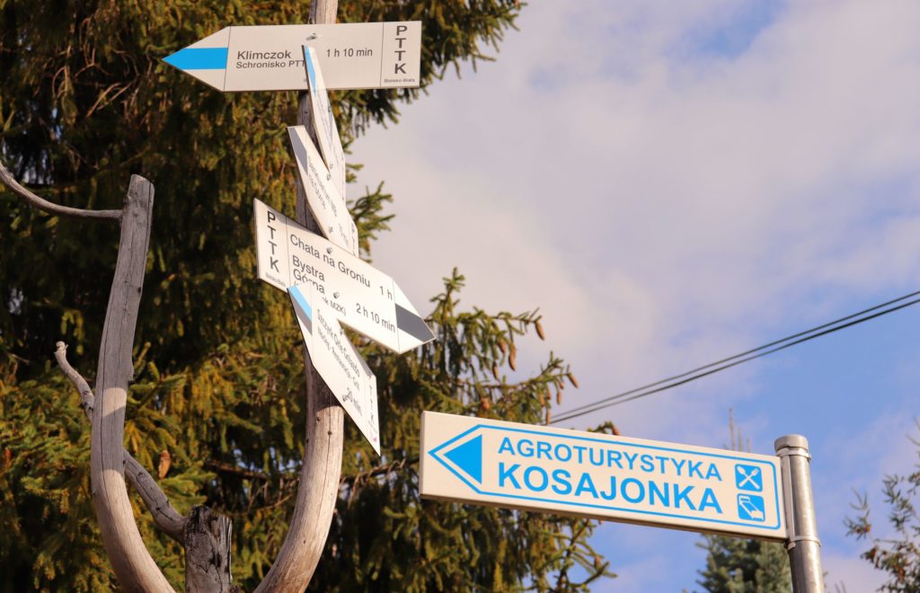 Słup z drogowskazami w Szczyrku, niebieski szlak na Klimczok (schronisko) 1 h 10 min