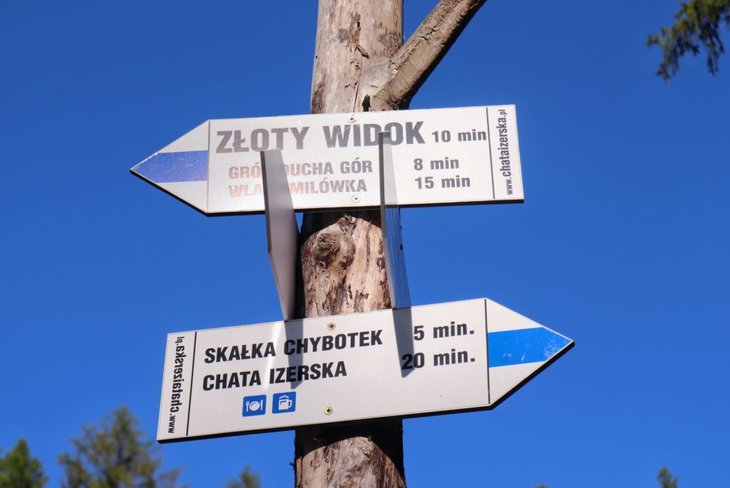 Słup z tabliczkami informujący o czasie dojścia niebieskim szlakiem do punktu widokowego Złoty Widok - 10 minut oraz do Skały Chybotek - 5 minut