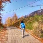 Turystka idąca szeroką, betonową drogą, Szczyrk - szlak niebieski prowadzący do Schroniska PTTK na Klimczoku