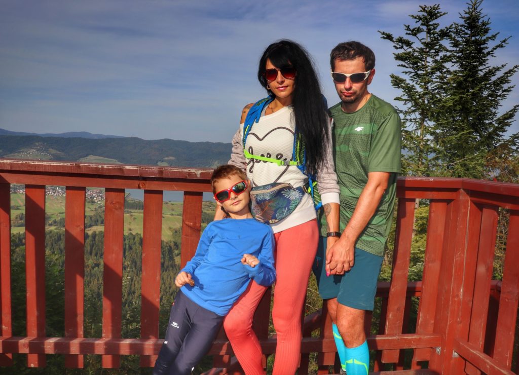 Turyści z dzieckiem na drewnianej wieży widokowej na szczycie Żar w Pieninach Spiskich
