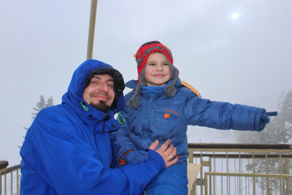 Uśmiechnięty turysta z dzieckiem na wieży widokowej na Baraniej Górze