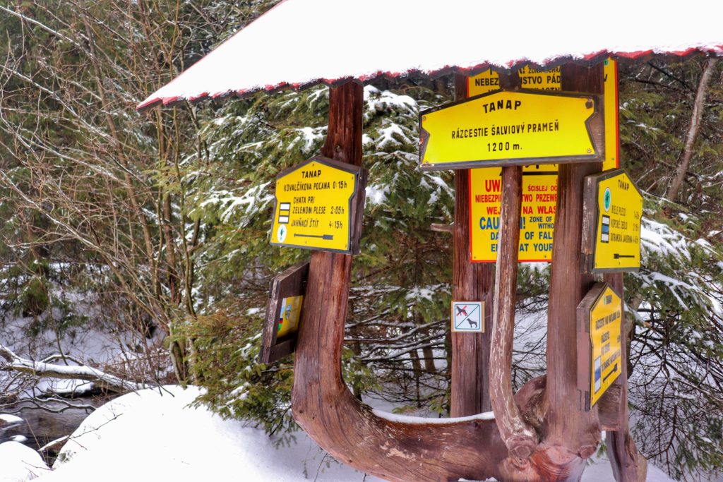 Żółta tablica w Tatrach Wysokich na Słowacji z napisem - Rozdroża Salviovy Prameń ( Razcestie Salviovy Pramen) -  1200 m n.p.m. zima