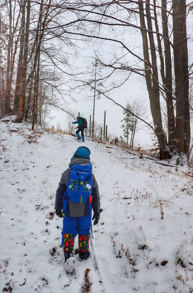 Dziecko, podejście na zielonym szlaku bazowym na Przysłop Potócki, zimowe warunki, w oddali inny turysta
