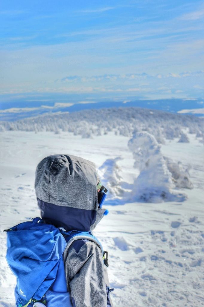 Dziecko podziwiające widoki rozciagające się ze szczytu Pilsko zimą, piękny zimowy dzień