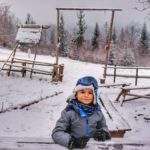 Dziecko siedzące przy zasypanym przez śnieg drewnianym stole, okolice bazy namiotowej - Przysłop Potócki