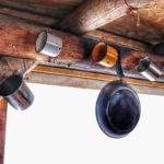 Stalowe kubki, patelnia wisząca nad oknem w chatce bazy noclegowej Przysłop Potócki