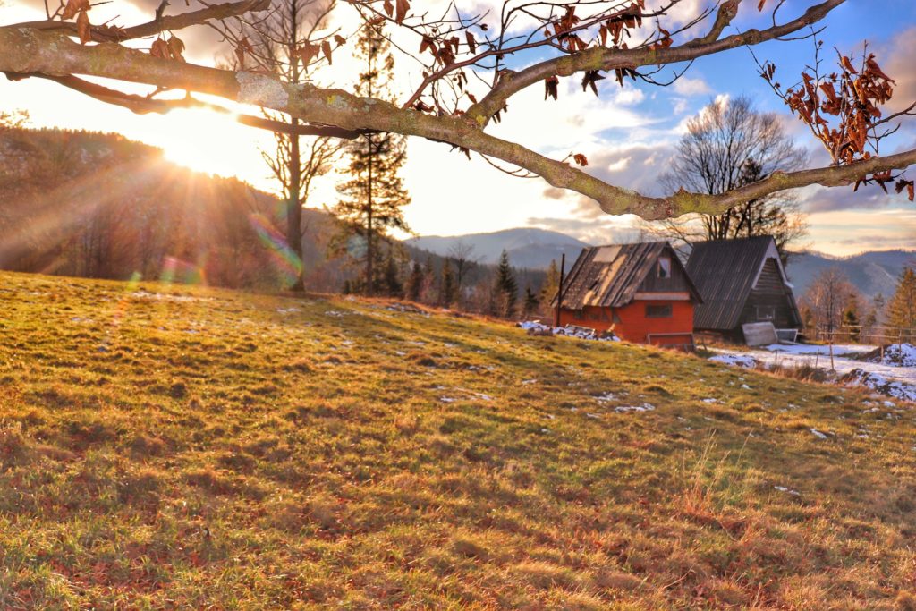 Słoneczny, grudniowy dzień na Przełęczy Przysłop Potócki, w oddali widoczne drewniane domki studenckiej bazy namiotowej