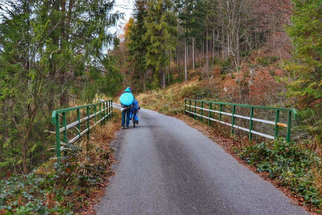 Turysta pchający dziecko jadące na rowerku, most, Kamesznica