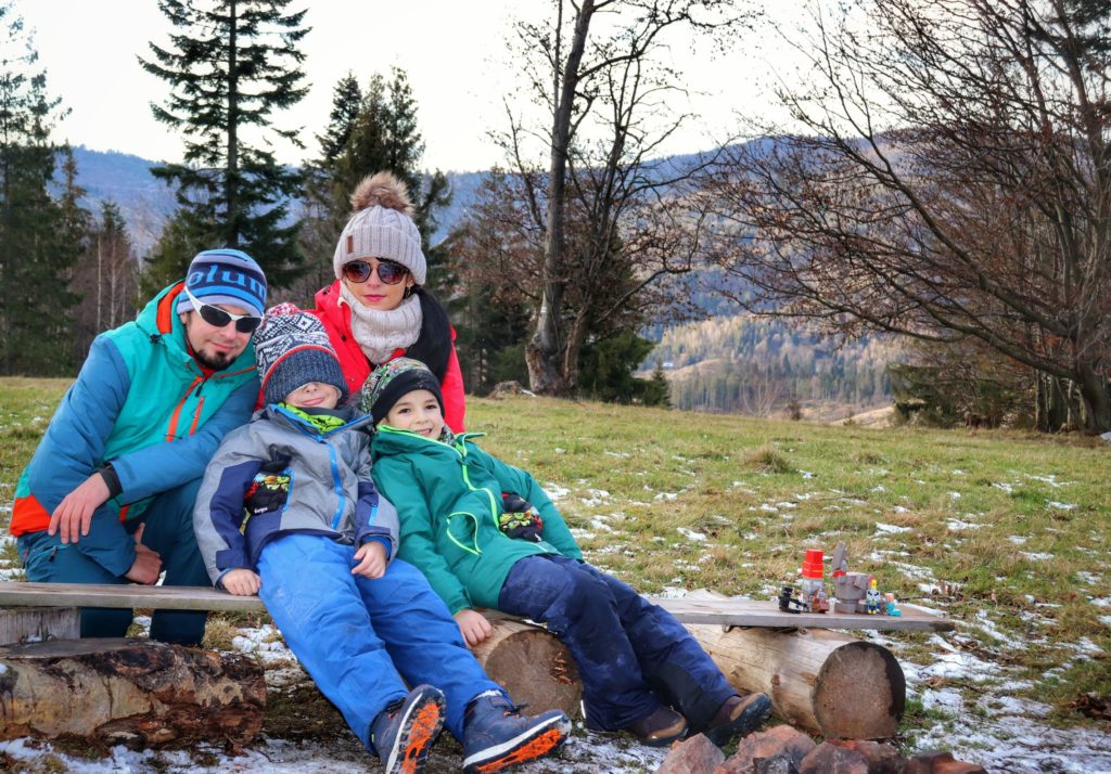 Turyści z dwójką dzieci odpoczywający na ławce przy Bazie Namiotowej Przysłop Potócki, jesienne popołudnie