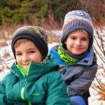 Uśmiechnięte dzieci, w tle resztki zalegającego śniegu