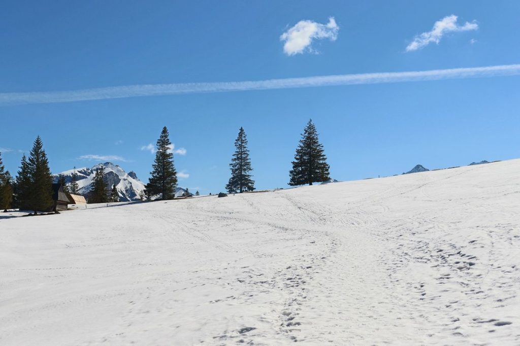 Wydeptana w śniegu ścieżka na niebieskim szlaku idącym przez Polanę Rusinową, niebieski niebo