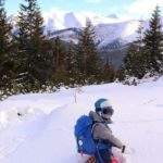 Dziecko bawiące się w głębokim śniegu, w tle ośnieżone, tatrzańskie szczyty