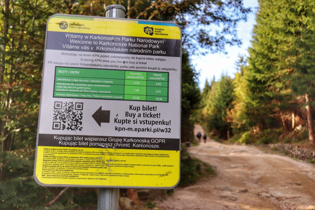 Tablica w Karkonoszach na żółtym szlaku do schroniska pod Łabskim Szczytem z obowiązującym cennikiem biletów do Karkonoskiego Parku Narodowego