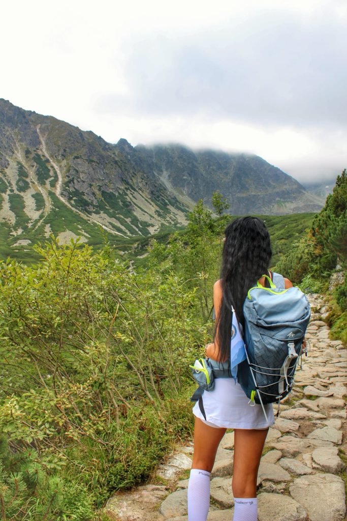 Turystka na niebieskim szlaku prowadzącym nad Czarny Staw Gąsienicowy podziwiająca tatrzańskie szczyty, kosodrzewina