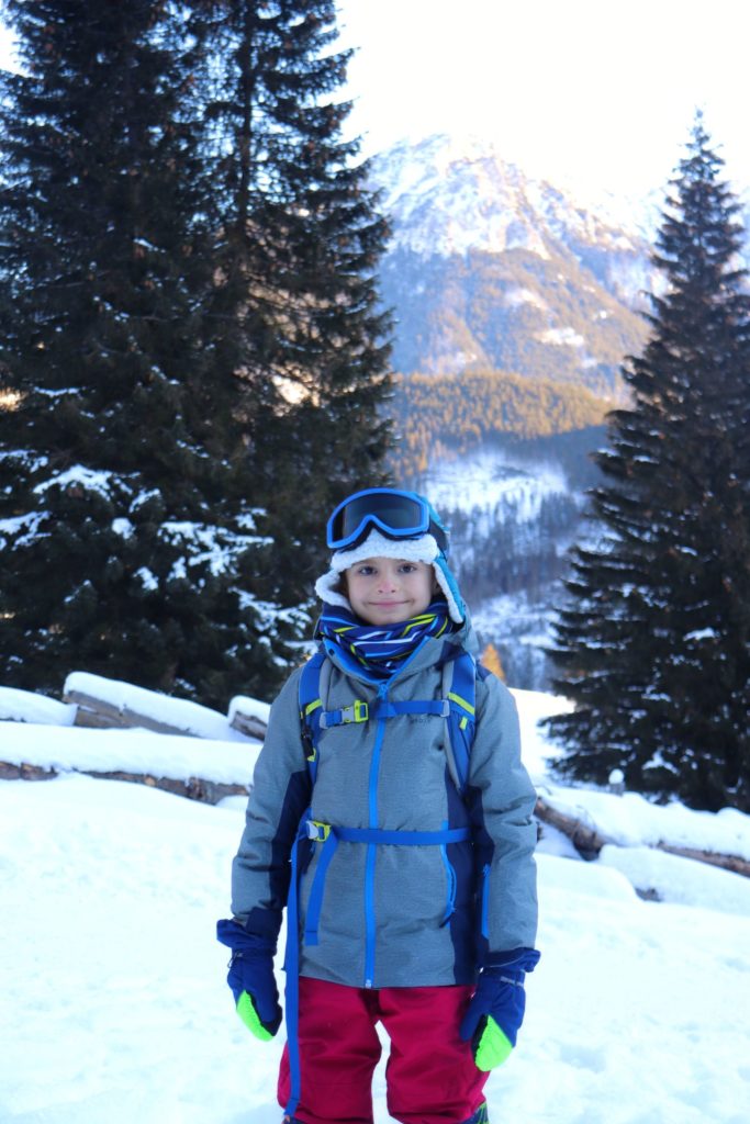 Zadowolone dziecko na tle zaśnieżonych Tatr, Polana Chochołowska