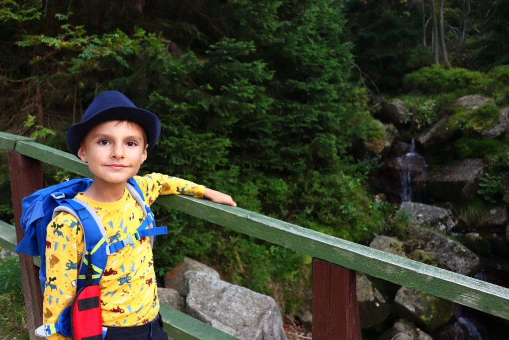 Zadowolony mały turysta, dziecko na mostku w okolicy Kukułczych Skał w Szkarskiej Porębie podziwiający  Szrenicki Potok