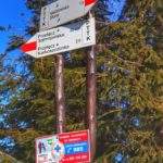 Drewniany słup z drogowskazami na szczycie Malinów (żółta tabliczka z napisem Malinów 1117 m n.p.m. )